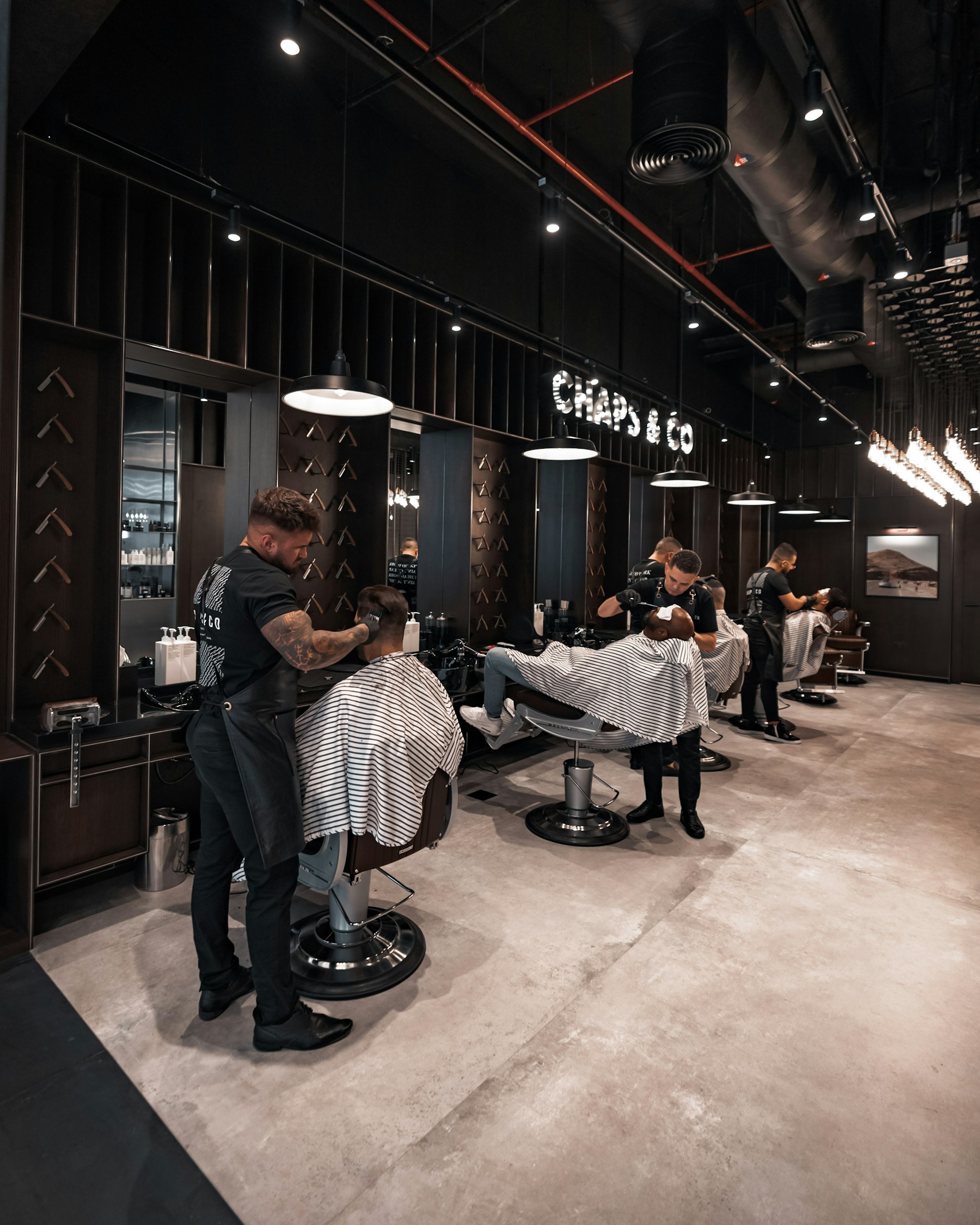 A team of barbers working together in a modern shop